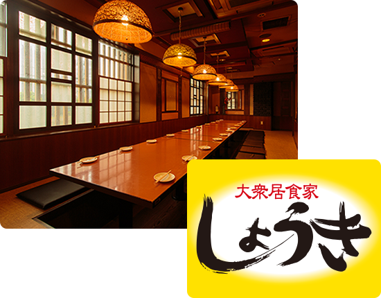 画像:大衆居食家しょうきの店内の様子。奥行きがある店内で、木目調の店内に、暖かい光でライトアップされています。テーブルには、お皿とお箸が並べられています。